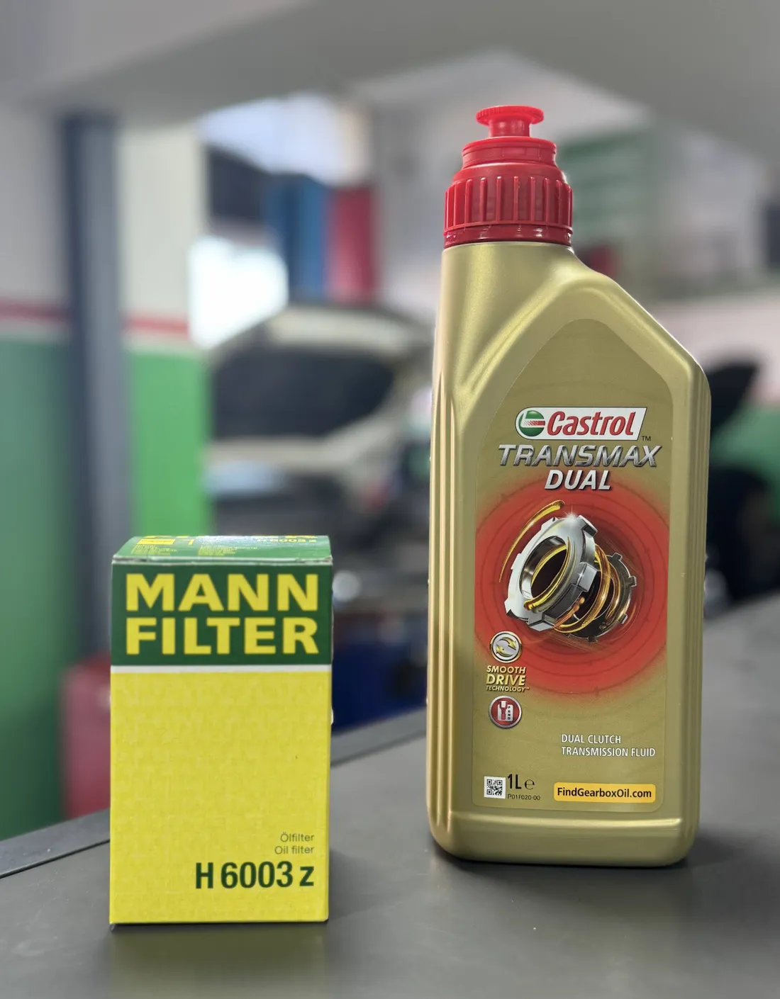 Bidon d'huile Castrol Transmax Dual et filtre à huile neuf, posés sur le comptoir du garage